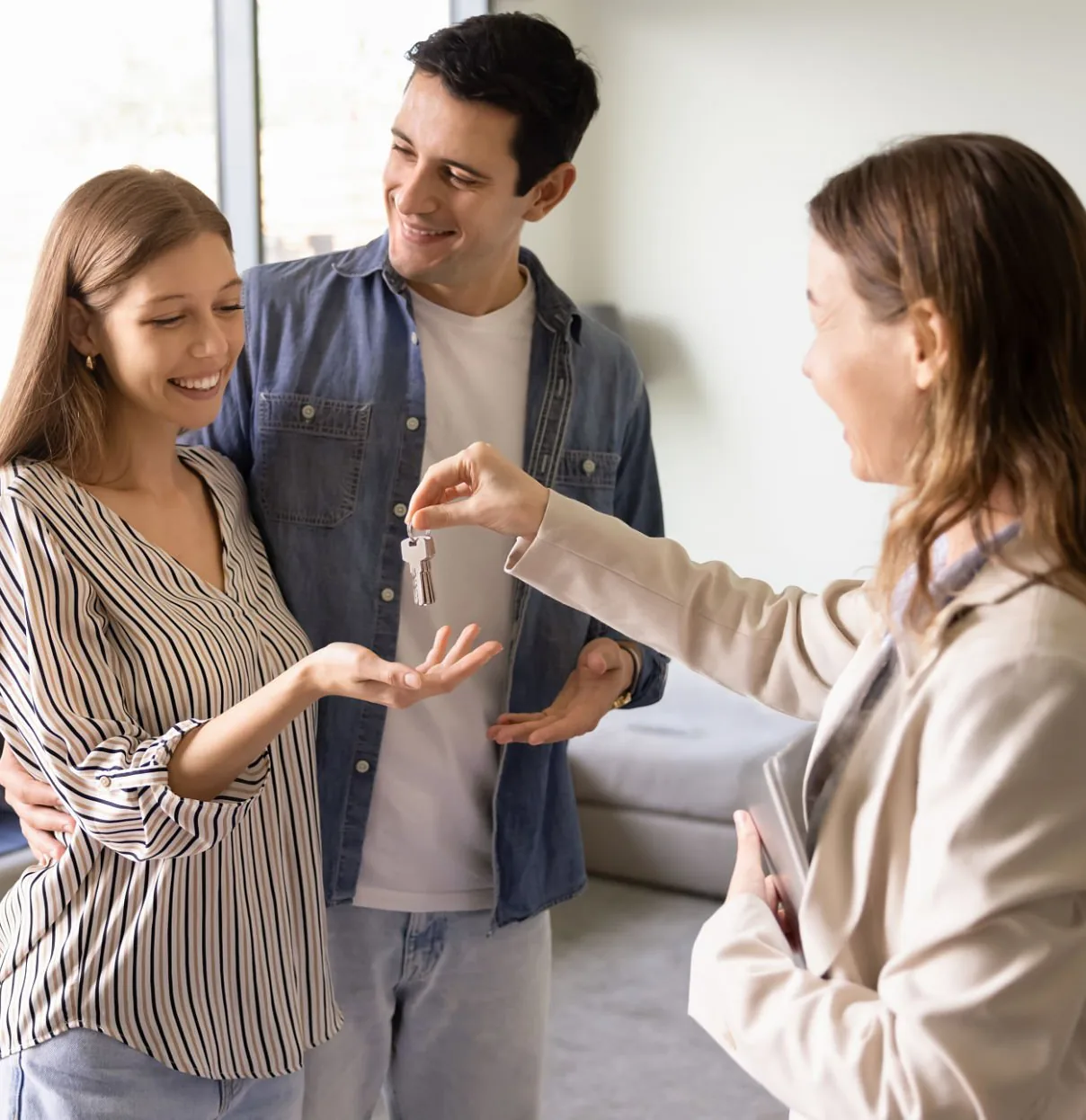 Property manager handing keys to a smiling couple