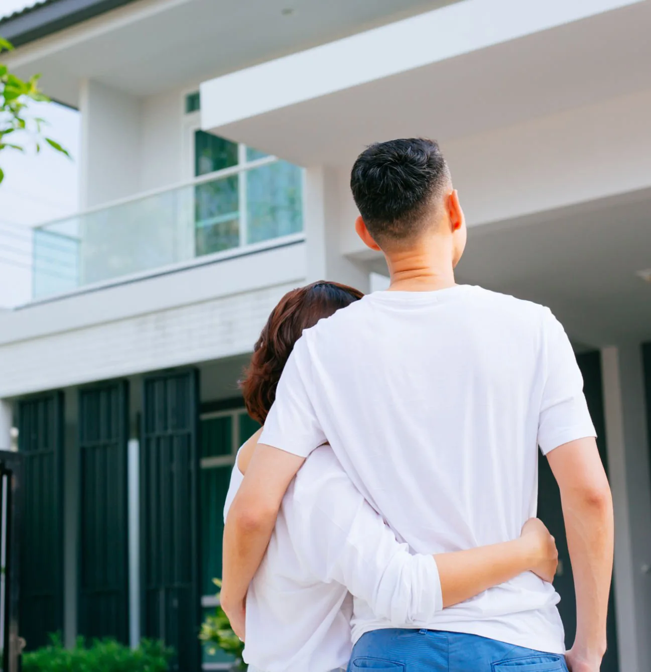 Couple embracing in front of their home